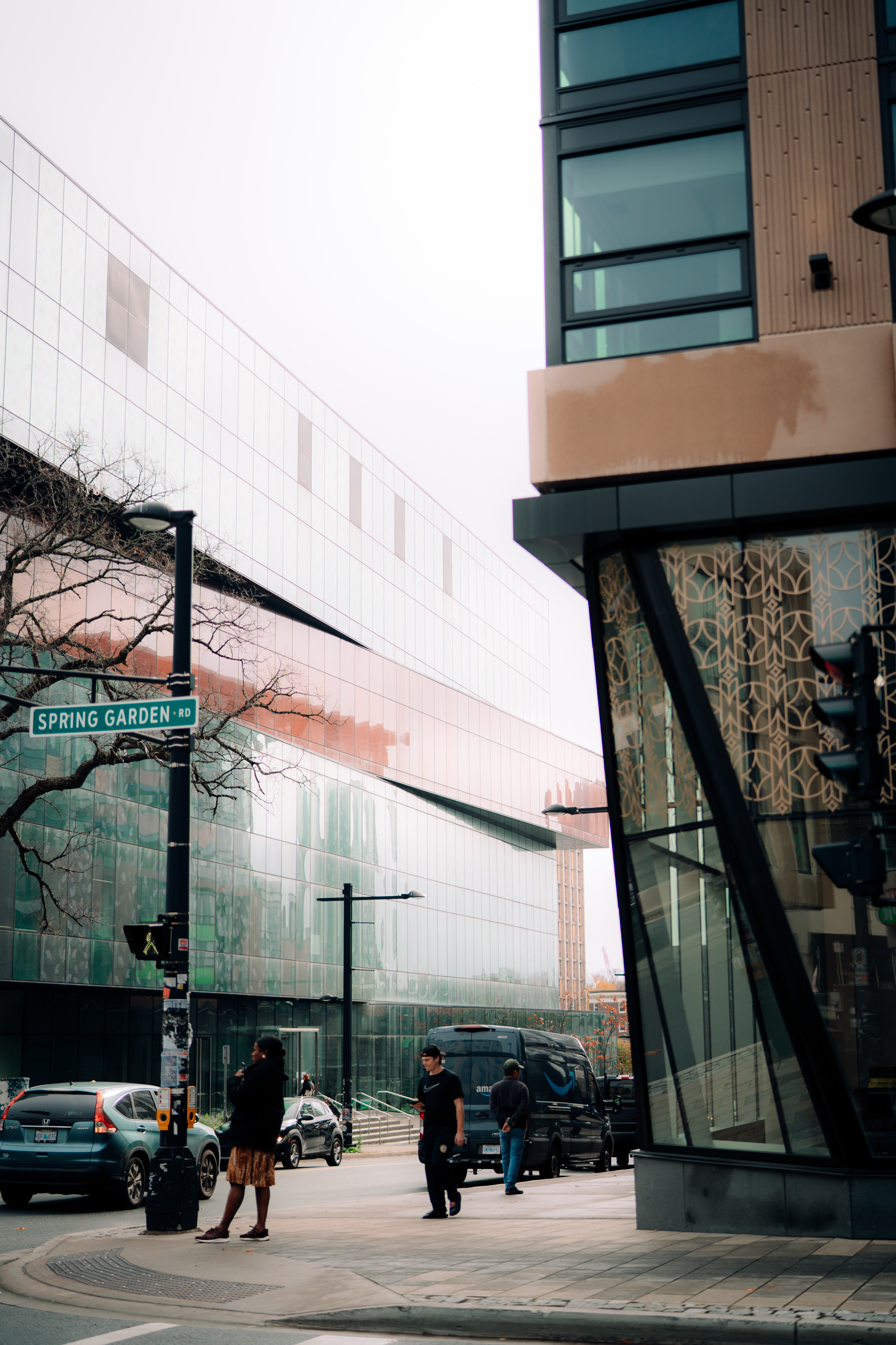 Foggy day outside the Halifax Central Library with pedestrians walking along Spring Garden Road.
