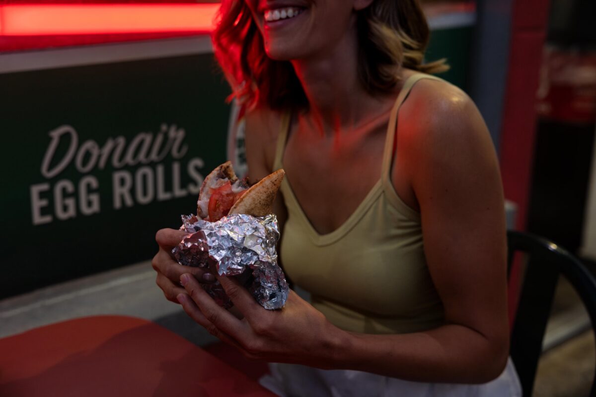 Woman holding a foil-wrapped Halifax donair at King of Donair.