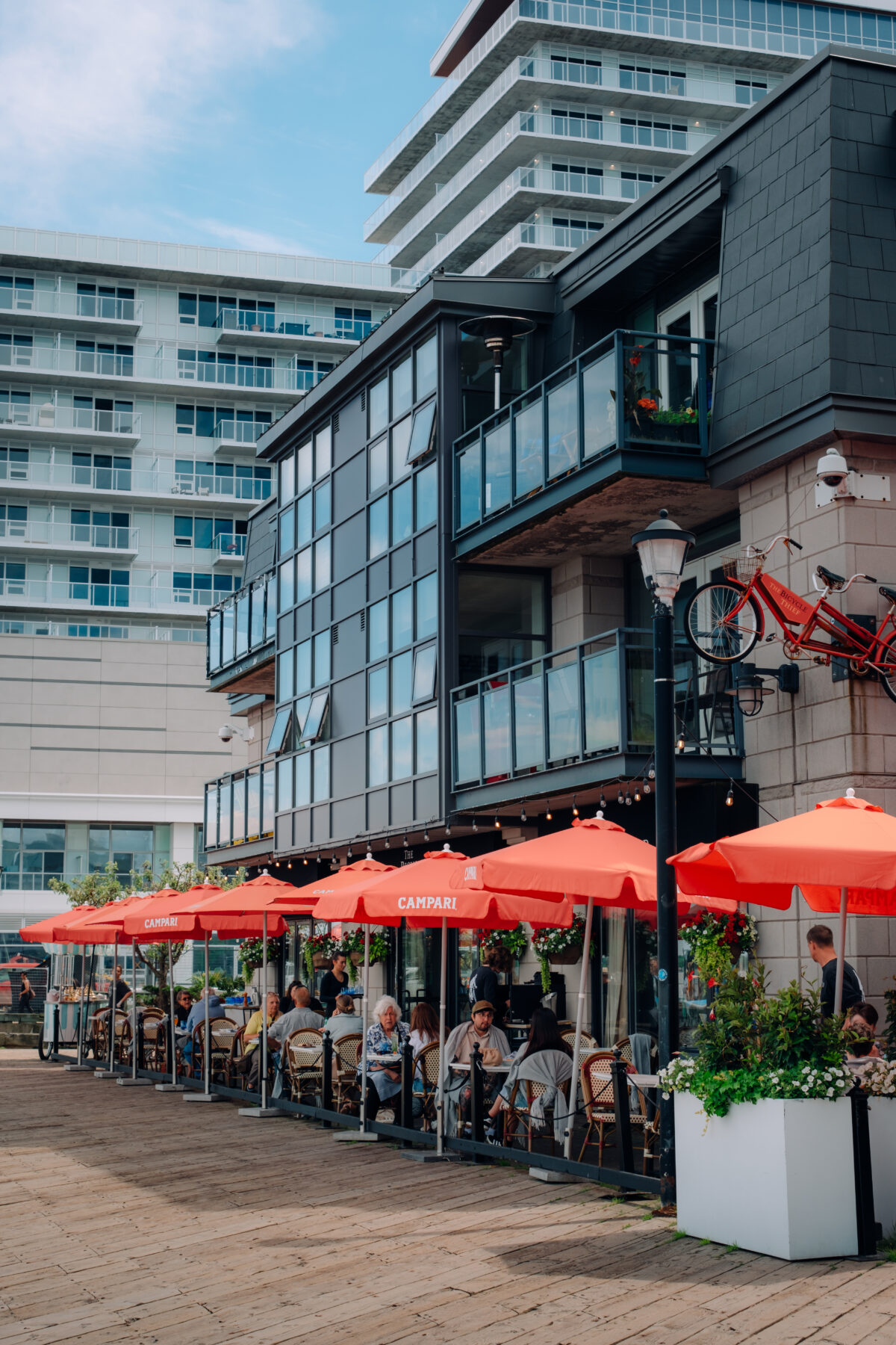 The Bicycle Thief restaurant patio on the Halifax Waterfront with red umbrellas and outdoor dining.