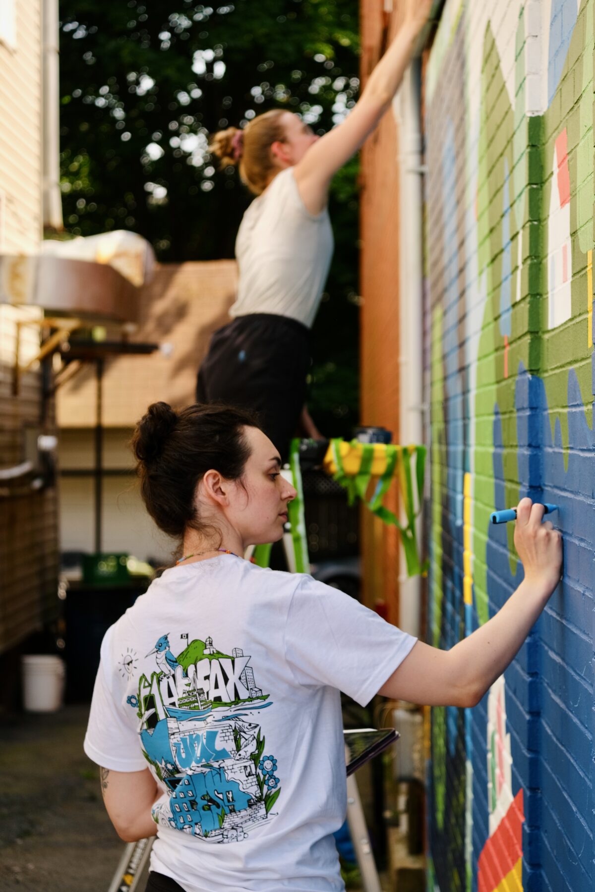 Molly Margaret and Ok-Island creating a mural at the Halifax Mural Festival.