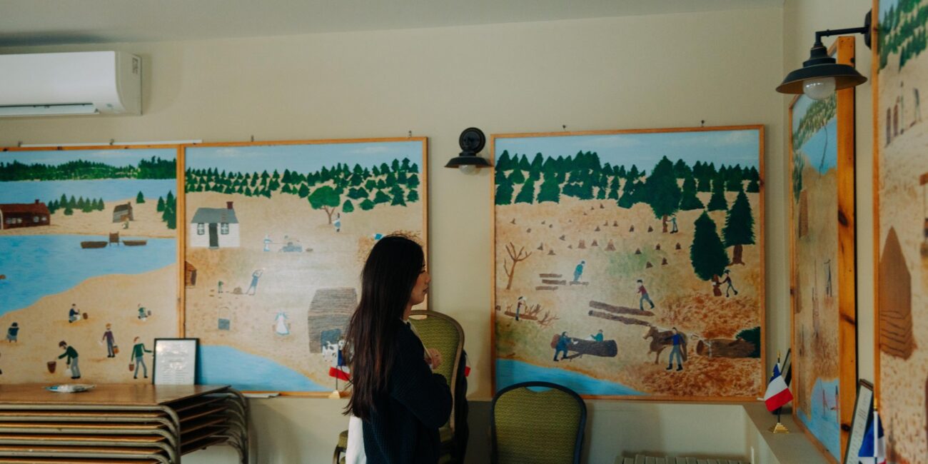 Visitor viewing Acadian art at L’Acadie de Chezzetcook
